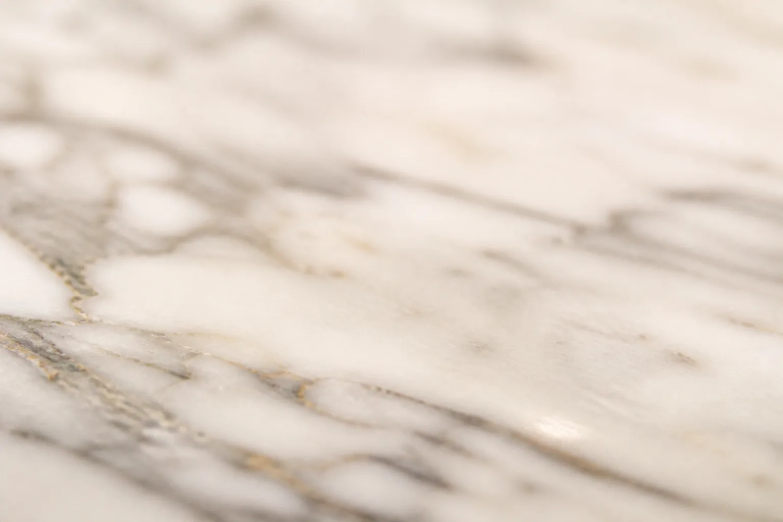 Close-up of polished white Italian Carrara marble with soft grey veining